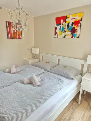 a bedroom with two beds and a chandelier at Nordseeperle Dirkshorn Nordholland, mit Klimaanlage und Sauna in Dirkshorn