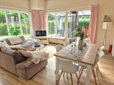 a living room with a couch and a table at Nordseeperle Dirkshorn Nordholland, mit Klimaanlage und Sauna in Dirkshorn