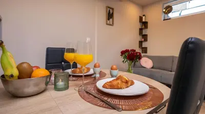 a dining room table with a plate of food and orange juice at Strandhuis aan zee in Noordwijk