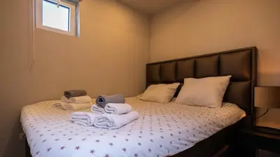 a bedroom with a bed with towels on it at Strandhuis aan zee in Noordwijk
