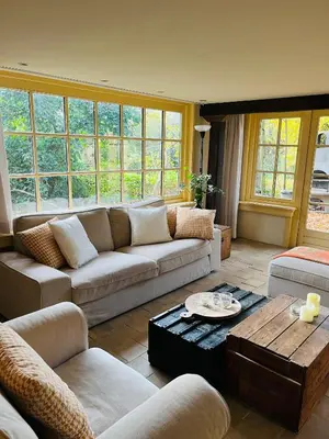 a living room with a couch and a coffee table at Cottage Het Beukenootje in Aerdenhout