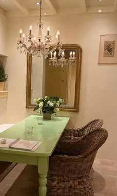 a dining room with a green table and a mirror at Cottage Het Beukenootje in Aerdenhout
