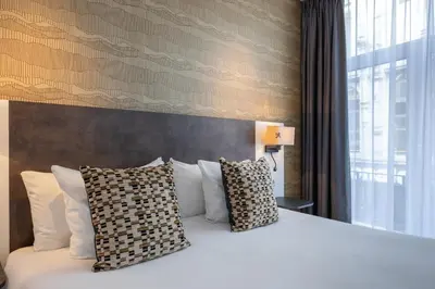 a bedroom with a white bed with two pillows at Hotel Amsterdam De Roode Leeuw in Amsterdam