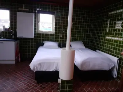 two beds in a room with green tiled walls at vakantiehuis Warder in Warder