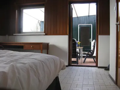 a bedroom with a bed and a desk and a chair at vakantiehuis Warder in Warder