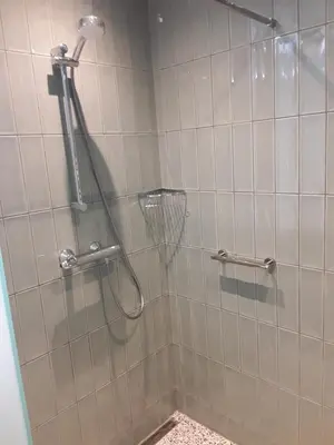 a shower in a bathroom with white tile at vakantiehuis Warder in Warder