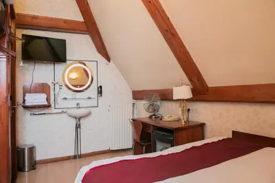 a bedroom with a bed and a desk and a tv at Hotel Atlanta in Amsterdam