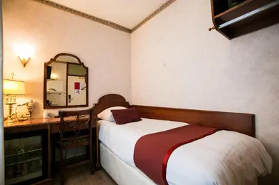 a bedroom with a bed and a desk and a mirror at Hotel Atlanta in Amsterdam
