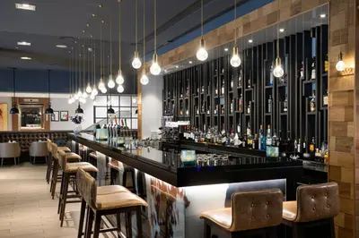 a bar in a restaurant with a bunch of bottles at Bilderberg Garden Hotel in Amsterdam
