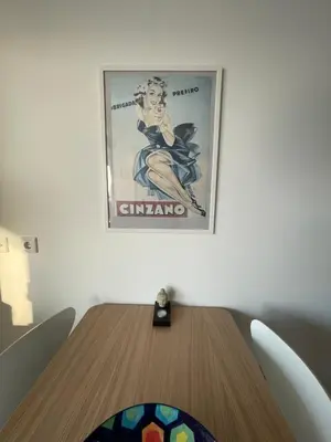 a picture hanging on a wall above a wooden table at North Sea Spirit in Zandvoort