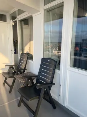 three black chairs sitting on a balcony with windows at North Sea Spirit in Zandvoort