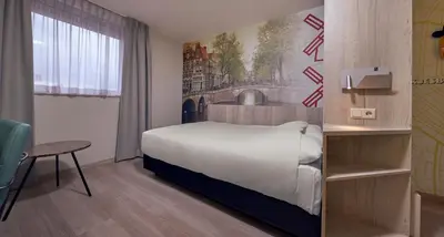 a hotel room with a bed and a table and a chair at Inntel Hotels Amsterdam Centre in Amsterdam