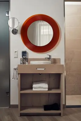 a bathroom with a sink and a mirror at Inntel Hotels Amsterdam Centre in Amsterdam