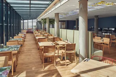 a row of tables and chairs in a restaurant at Inntel Hotels Amsterdam Centre in Amsterdam