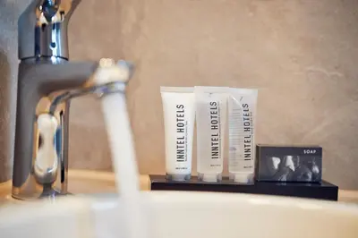 a bathroom sink with two tubes of toothpaste and a faucet at Inntel Hotels Amsterdam Centre in Amsterdam