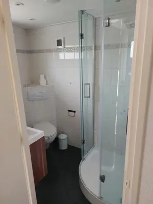 a bathroom with a toilet and a glass shower at Cappuccetto Rosso in Nieuwe-Niedorp