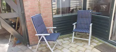 two blue and white chairs sitting on a porch at Cappuccetto Rosso in Nieuwe-Niedorp