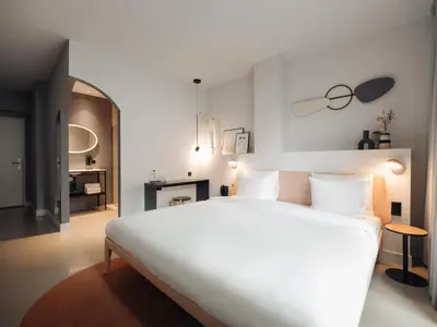 a bedroom with a large white bed and a fireplace at Conscious Hotel Museum Square in Amsterdam