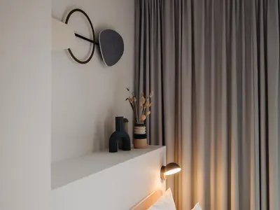 a white mantle with a mirror and a curtain at Conscious Hotel Museum Square in Amsterdam