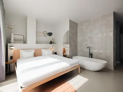 a bedroom with a large bed and a bath tub at Conscious Hotel Museum Square in Amsterdam
