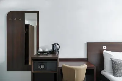a bedroom with a desk and a bed and a mirror at Hotel City Garden Amsterdam in Amsterdam