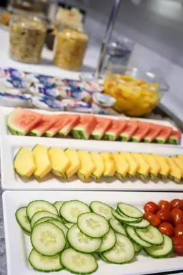 a buffet of food with cucumbers and other fruits and vegetables at Hotel City Garden Amsterdam in Amsterdam