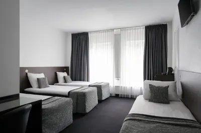 a hotel room with two beds and a couch at Hotel City Garden Amsterdam in Amsterdam