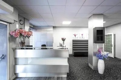 a lobby with vases of flowers and a reception desk at Hotel City Garden Amsterdam in Amsterdam