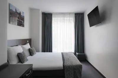 a hotel room with a bed and a window at Hotel City Garden Amsterdam in Amsterdam