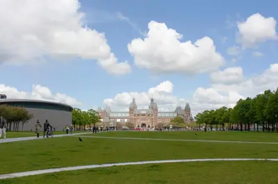 a large building in a park with people walking around at Budget Trianon Hotel in Amsterdam