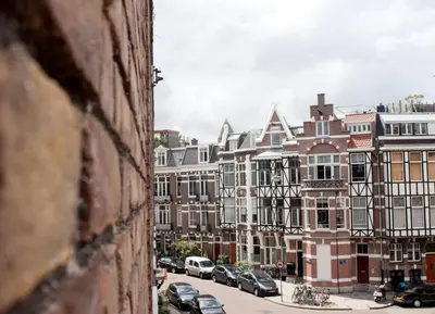 a city street with cars parked in front of buildings at Budget Trianon Hotel in Amsterdam