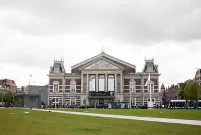 a large building with a grass field in front of it at Budget Trianon Hotel in Amsterdam