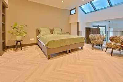 a bedroom with a bed and two chairs and a window at PRIVATE APPARTMENT 60m2 - CENTRE TOP LOCATION in Amsterdam