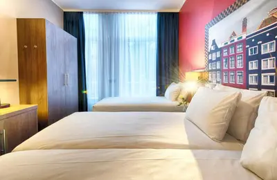 a hotel room with two beds and a large window at Leonardo Boutique Hotel Amsterdam Vondelpark in Amsterdam