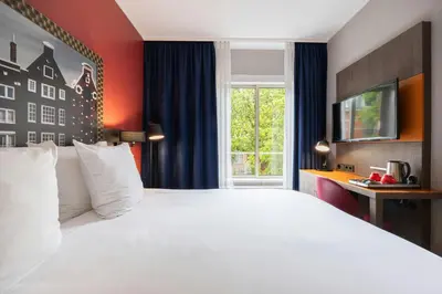 a bedroom with a large white bed and a window at Leonardo Boutique Hotel Amsterdam Vondelpark in Amsterdam