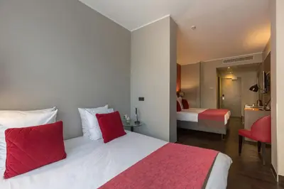a bedroom with a large bed with red pillows at Leonardo Boutique Hotel Amsterdam Vondelpark in Amsterdam