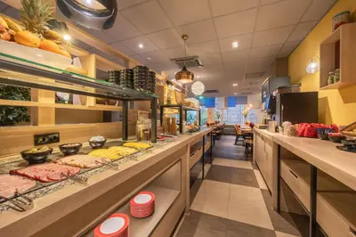 a restaurant with a long counter with food at Leonardo Boutique Hotel Amsterdam Vondelpark in Amsterdam