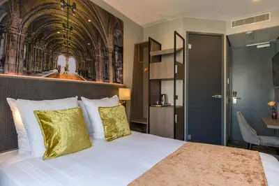 a bedroom with a large white bed with yellow pillows at Leonardo Hotel Amsterdam Museum Quarter in Amsterdam
