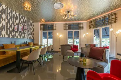 a restaurant with tables and chairs in a room at Leonardo Hotel Amsterdam Museum Quarter in Amsterdam