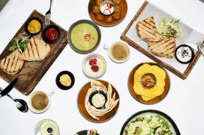 a white table with plates of food on it at Leonardo Hotel Amsterdam Museum Quarter in Amsterdam