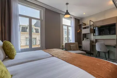 a bedroom with a large bed with a large window at Leonardo Hotel Amsterdam Museum Quarter in Amsterdam