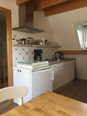 a kitchen with a white stove top oven next to a table at Holiday in Spakenburg t Afferhuus in Spakenburg