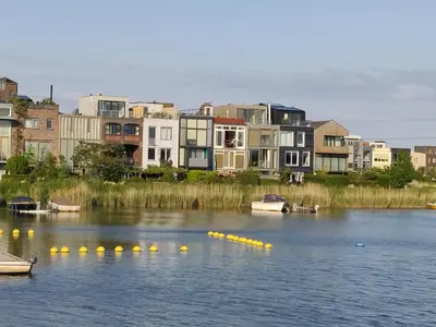 a group of boats in the water with buildings at House of Straw Amsterdam in Amsterdam