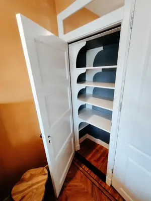 a closet with white shelves and a door at House of Straw Amsterdam in Amsterdam