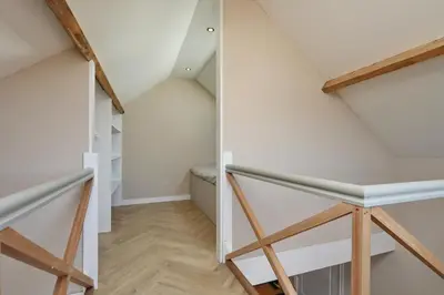 a staircase in a loft conversion with white walls and wood floors at appartement-gratis parkeren -bij strand en in het centrum in Noordwijk