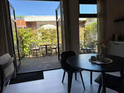 a dining room with a table and a patio at Zilt aan Zee in Egmond aan Zee