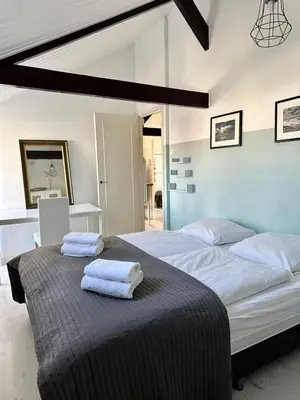 a bedroom with a large bed with towels on it at Ozzy's Beach House in Zandvoort