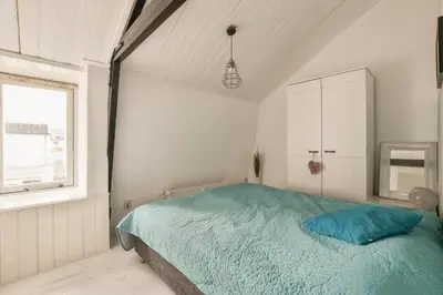 a bedroom with a blue bed and a window at Ozzy's Beach House in Zandvoort