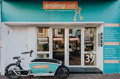 a bike parked in front of a shop with a cooler on it at Ozzy's Beach House in Zandvoort