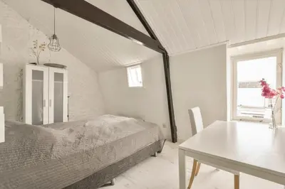 a bedroom with a bed and a table and a window at Ozzy's Beach House in Zandvoort
